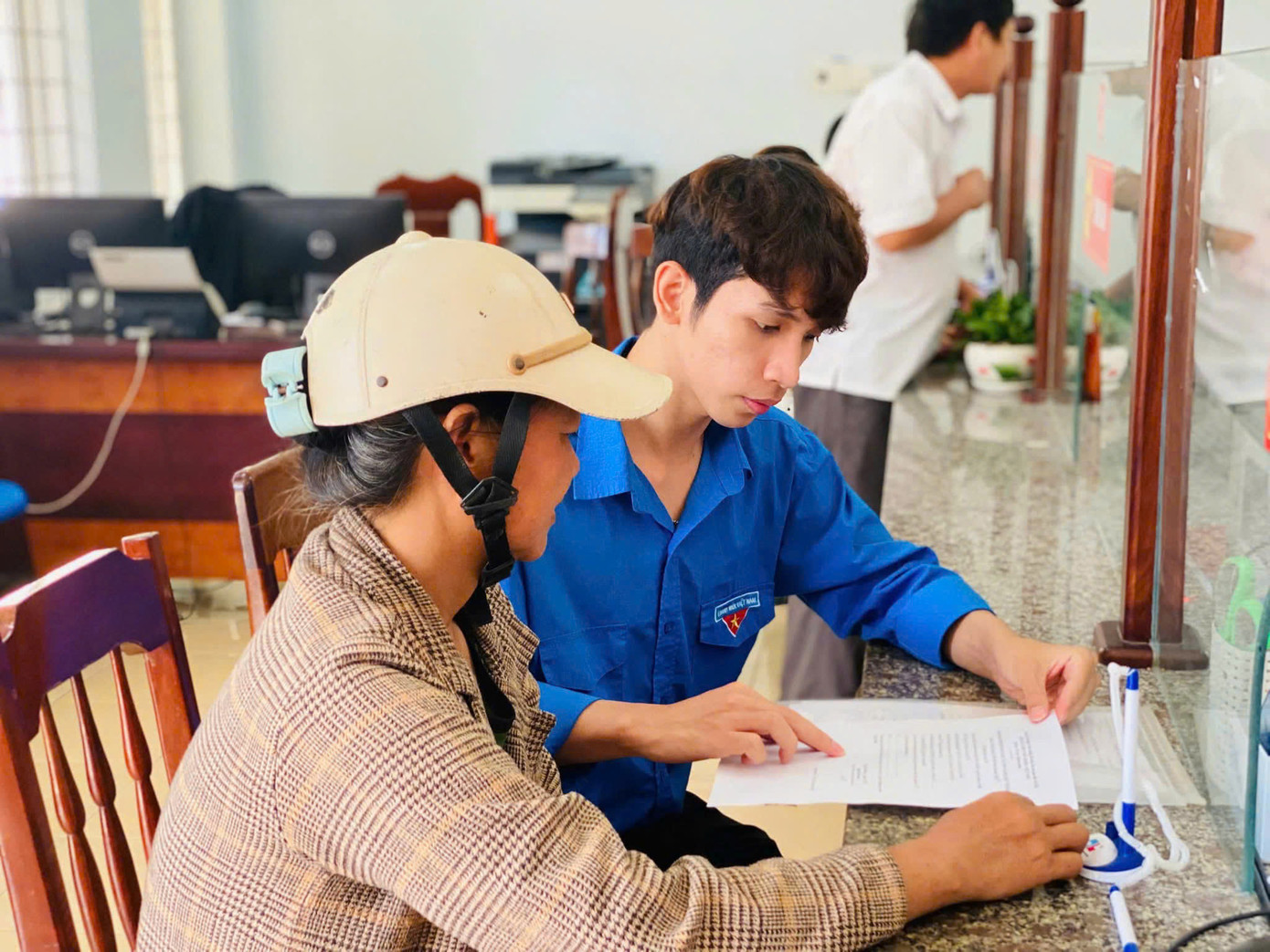 Các đội hình thanh niên tình nguyện phối hợp với lực lượng chức năng hỗ trợ người dân sử dụng các dịch vụ công trực tuyến. Ảnh: Nguyễn Ngọc