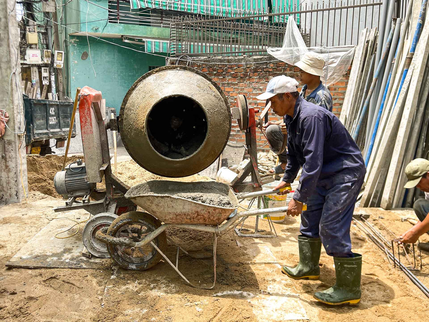 Trong những ngày nắng Đà Nẵng nóng đỉnh điểm, trời lại không có chút gió, cộng với bụi công trình, hơi nóng tỏa ra từ bê tông, sắt thép... càng làm những người thợ xây thêm vất vả. Vật dụng chống nắng tốt nhất với họ chỉ là một chiếc mũ và áo dài tay. (Ảnh: Thanh An)