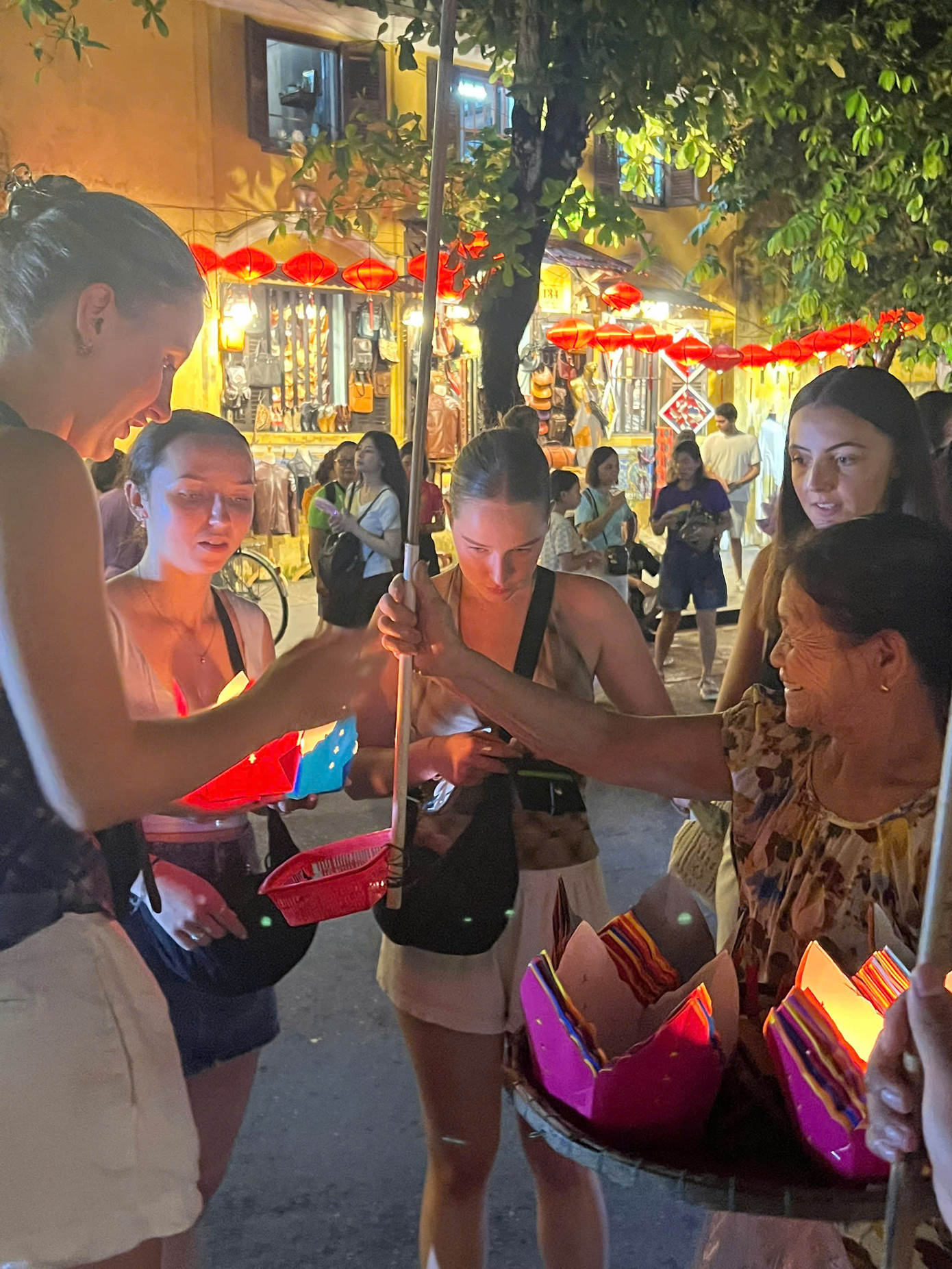 Du khách nước ngoài thích thú với những chiếc hoa đăng của bà Sáu. Ảnh: Văn Nhất