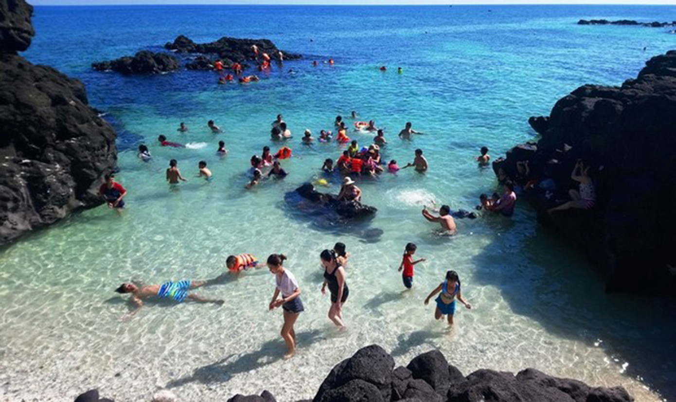 Du khách bơi lặn giữa làn nước biển trong xanh ở đảo Bé (huyện Lý Sơn, tỉnh Quảng Ngãi).