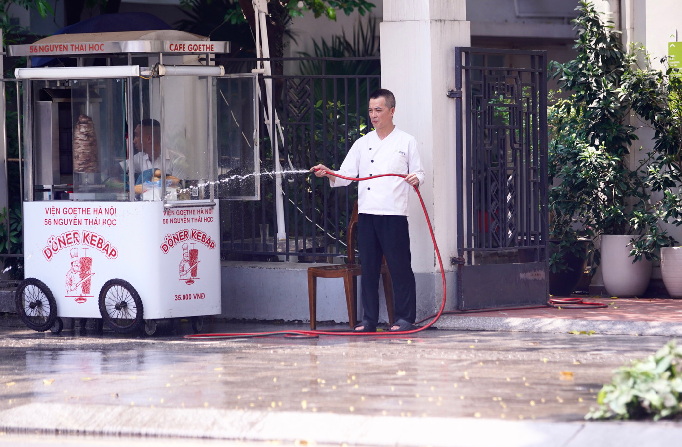 Người đàn ông tưới nước để giảm nhiệt độ vỉa hè. Người đàn ông tưới nước để giảm nhiệt độ vỉa hè.