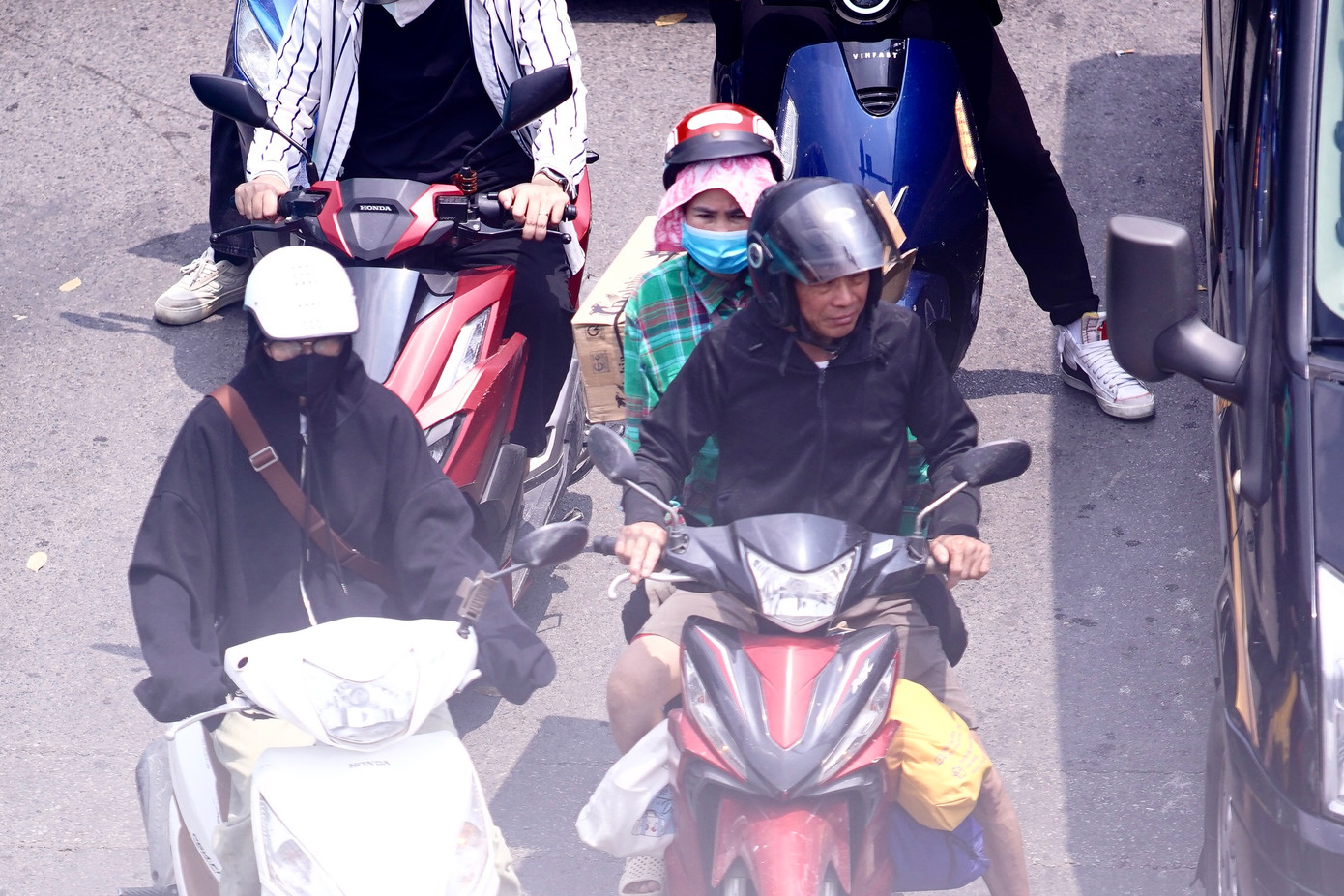 Người phụ nữ dùng khăn lót dưới mũ bảo hiểm để chống chọi với cái nắng nóng. Người phụ nữ dùng khăn lót dưới mũ bảo hiểm để chống chọi với cái nắng nóng.