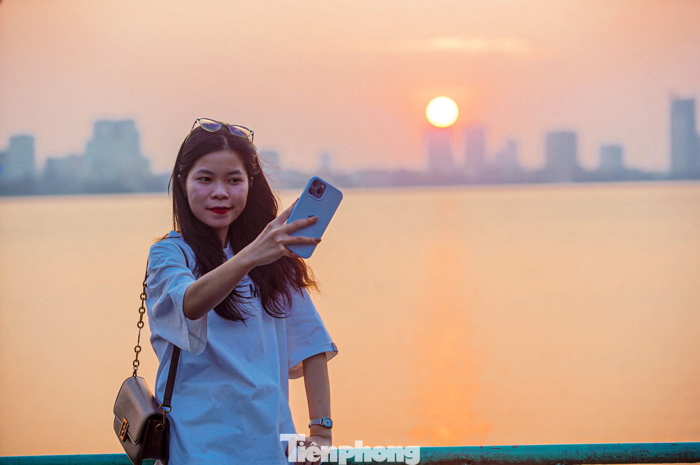 "Em bấm máy liên tục, bắt trọn từng khoảnh khắc khi mặt trời buông xuống, cứ 10 giây là màu mặt trời trở nên khác, nắng không còn gắt", bạn Hoa (Thanh Xuân, Hà Nội) chia sẻ.