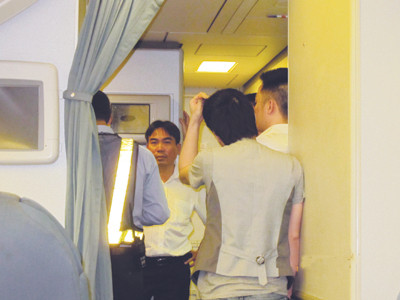 Ca sĩ Quang Hà (tay gãi đầu) đứng trong khoang thương gia Ảnh: Eileen Tan (người Singapore)