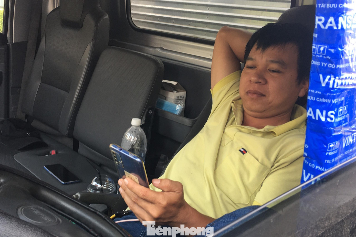 Một tài xế ngồi bấm điện thoại &quot;giết&quot; thời gian trong lúc chờ giải tỏa ùn tắc.