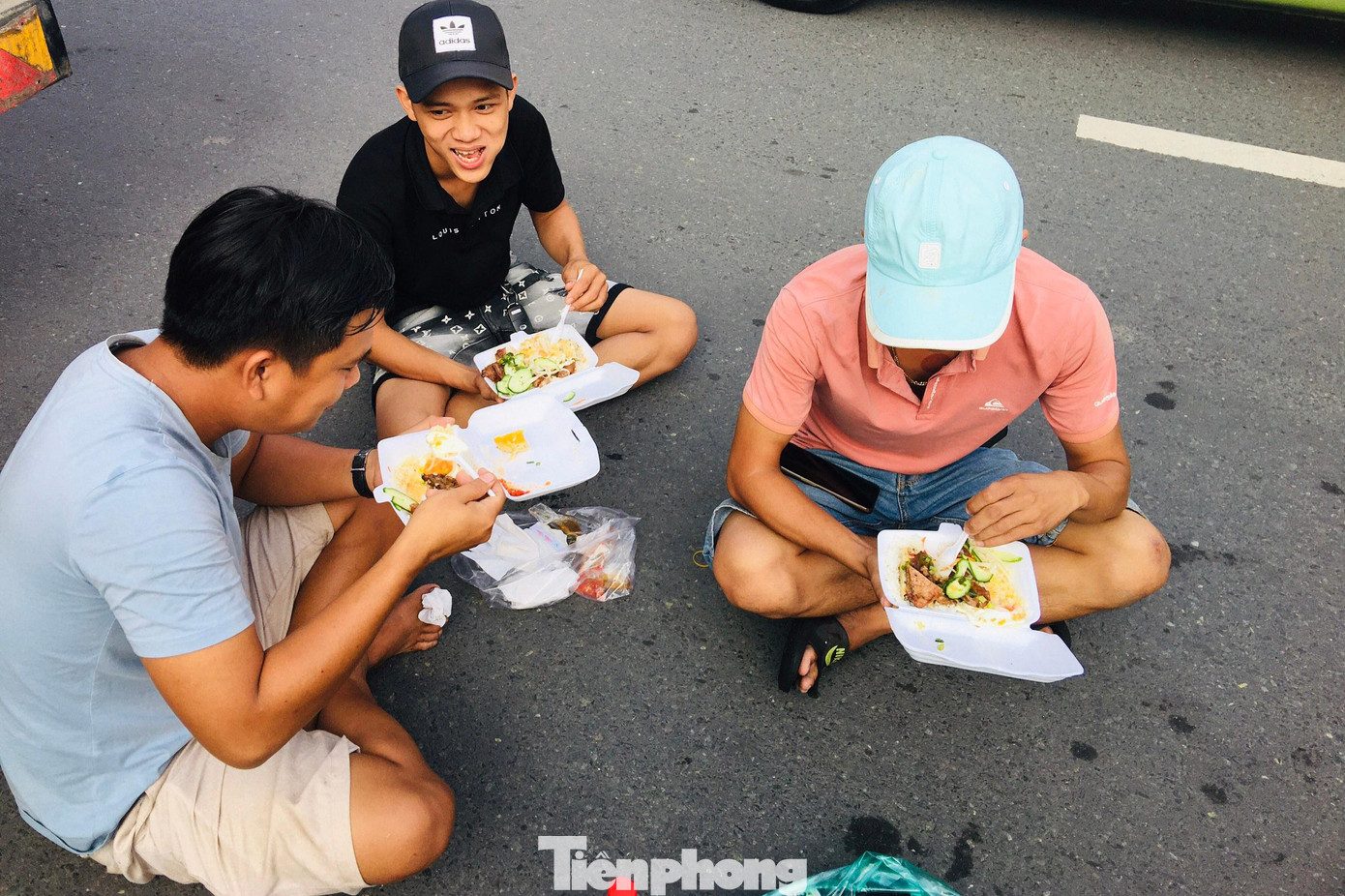 Kẹt xe quá lâu khiến các tài xế mệt mỏi, nhiều người phải đặt mua cơm hộp rồi ngồi bệt dưới mặt đường để ăn trưa.