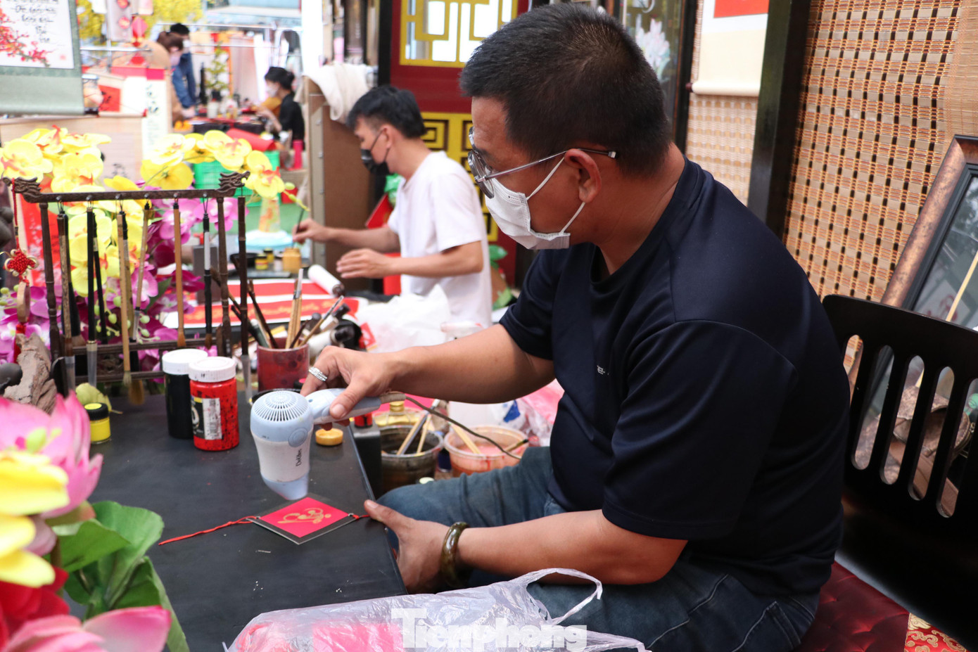 Chữ sau khi được viết trên tấm thiệp liền được các ông đồ dùng máy sấy để sấy cho nhanh khô để tránh bị nhòe màu khi giao cho khách.