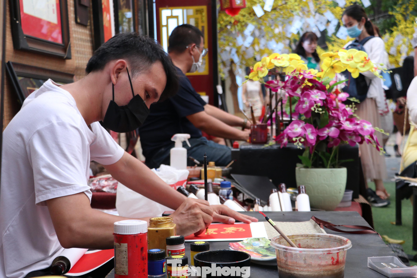 Các ông đồ, bà đồ luôn tất bật với công việc viết chữ, vẽ tranh để bán cho khách tham quan.