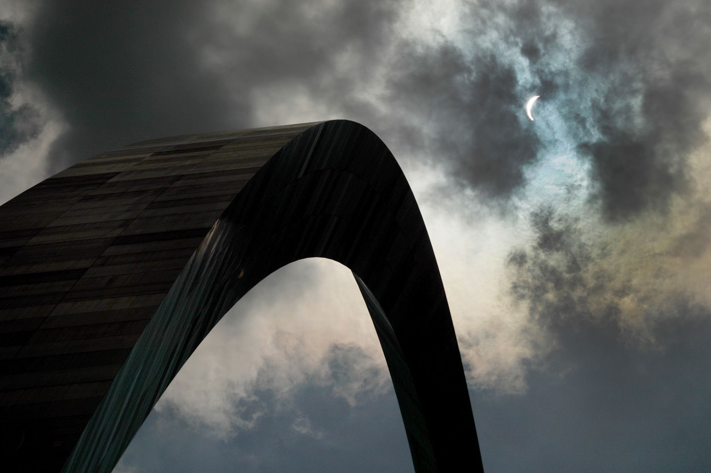 Mặt trăng che một phần mặt trời trên bầu trời nhiều mây vào ngày 21 tháng 8 năm 2017, trên Cổng vòm ở St. Louis.