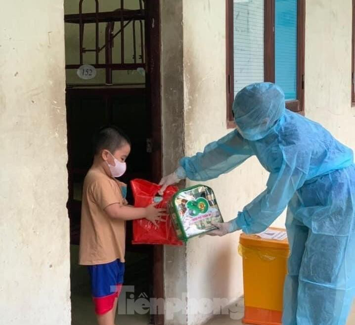 Tình nguyện viên tặng quà cho bé trai trong khu cách ly Tình nguyện viên tặng quà cho bé trai trong khu cách ly