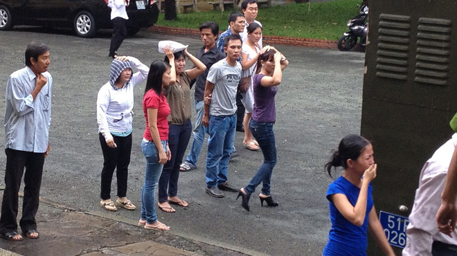 Người thân của các bị cáo đứng khóc dưới trời mưa, nhìn theo xe tù tại TAND TP.HCM tháng 7-2012. Trong vụ án này có đến năm người lãnh án tử hình. Ảnh: Tâm Lụa