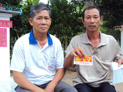 Ông Tùng (phải) và tờ vé số rách, không thể lĩnh thưởng. Ông Tùng (phải) và tờ vé số rách không thể lĩnh thưởng