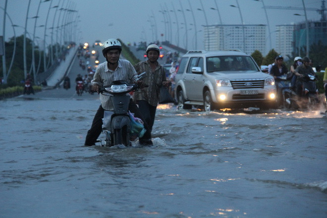 Nước ngập sâu vì triều cường khiến nhiều xe máy qua khu vực chân cầu Thủ Thiêm (Q.2) chết máy, phải dắt bộ - Ảnh: Q.Khải