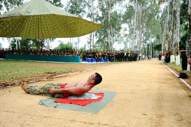 Một trong những buổi tập và biểu diễn tại trường của các học viên trường Sĩ quan Đặc công. Lưng trần nằm lên đống kính vỡ sắc nhọn