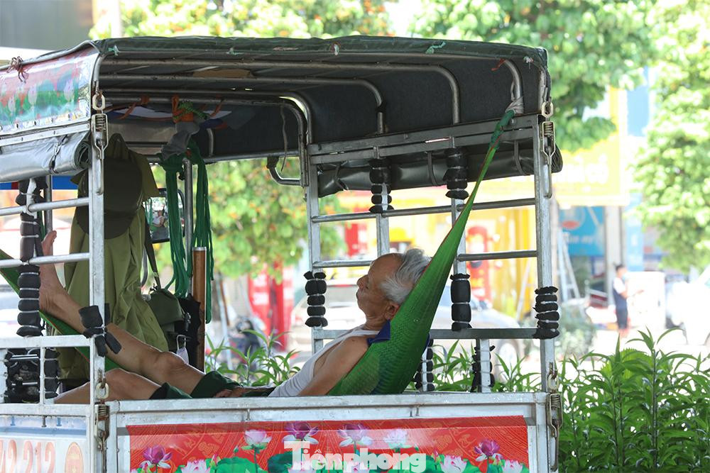 Một bác lái xe mắc võng nghỉ trưa dưới gầm đường vành đai 3 trên đường Nguyễn Xiển