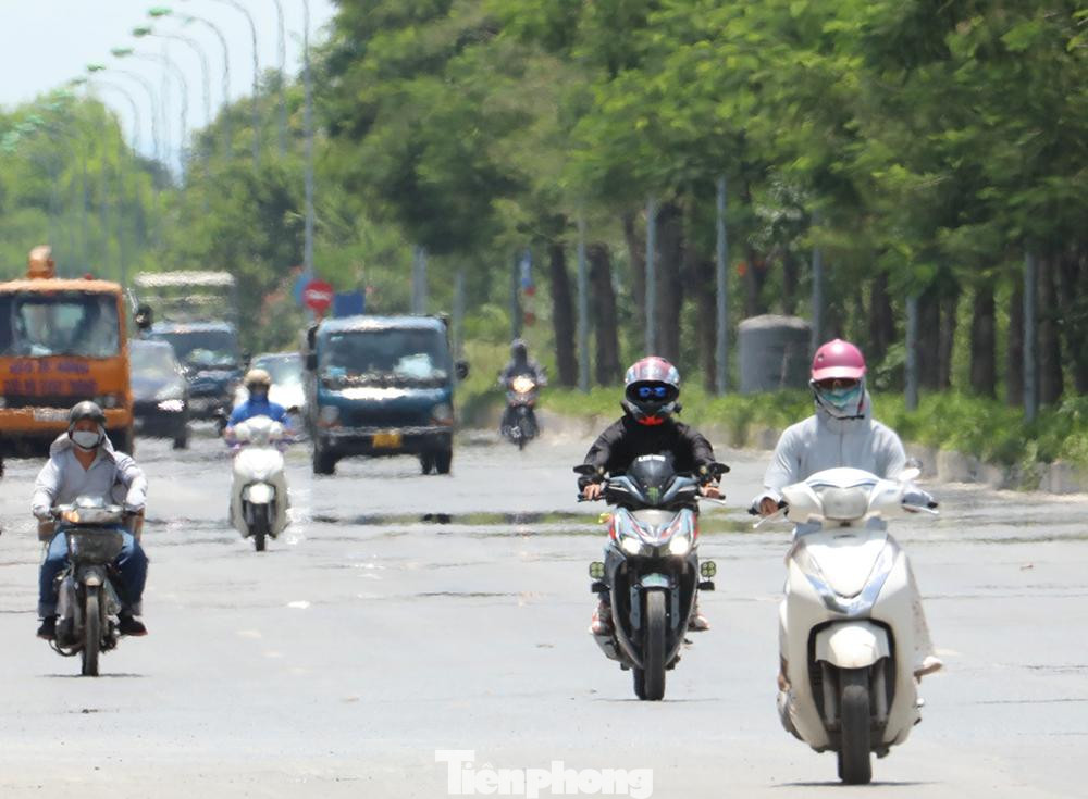 Người đi xe máy bịt kín từ đầu đến chân giữa trưa nắng