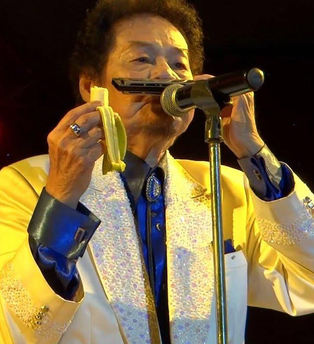 Nghệ sỹ Tòng Sơn trình diễn tiết mục vừa thổi kèn vừa ăn chuối