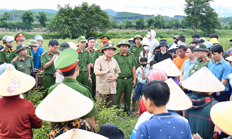 Đại tá Nguyễn Hữu Hợp (áo kẻ, đội mũ cối) trao đổi với người dân.