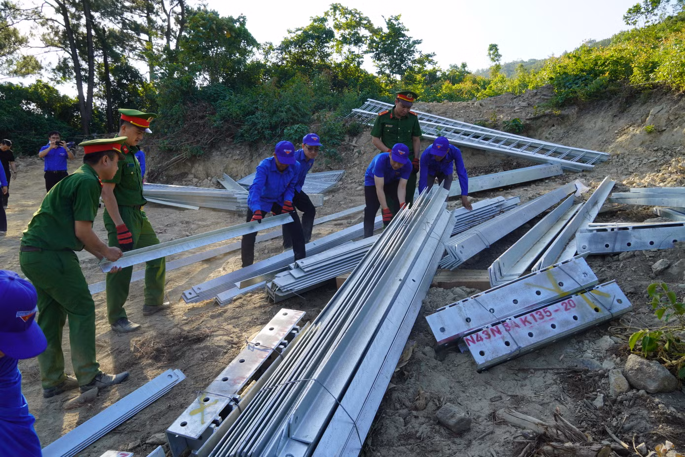 Lực lượng thanh niên tình nguyện giúp vận chuyển thiết bị lắp đặt trụ điện số 6. Lực lượng thanh niên tình nguyện giúp vận chuyển thiết bị lắp đặt trụ điện số 6.
