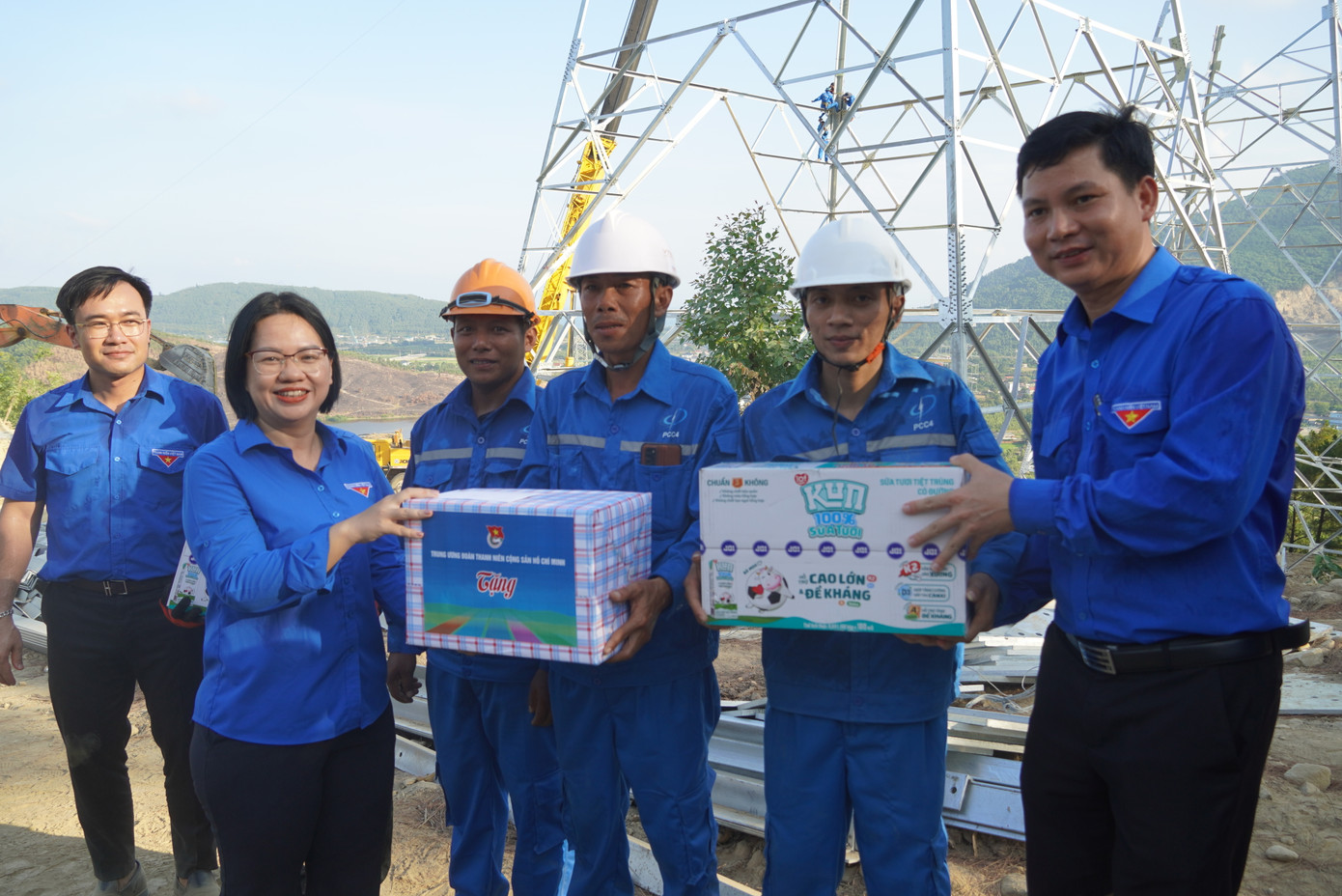 Chị Nguyễn Thị Thu Vân và anh Đặng Đại Bàng tặng quà cho anh em công nhân và đội hình tình nguyện đang thi công tại trụ điện số 6.