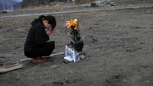 Cô Mika Hashikai, 37 tuổi đang cầu nguyện cho người cha quá cố đã mất tích trong thảm họa năm 2011. Cô Mika Hashikai, 37 tuổi đang cầu nguyện cho người cha quá cố đã mất tích trong thảm họa năm 2011