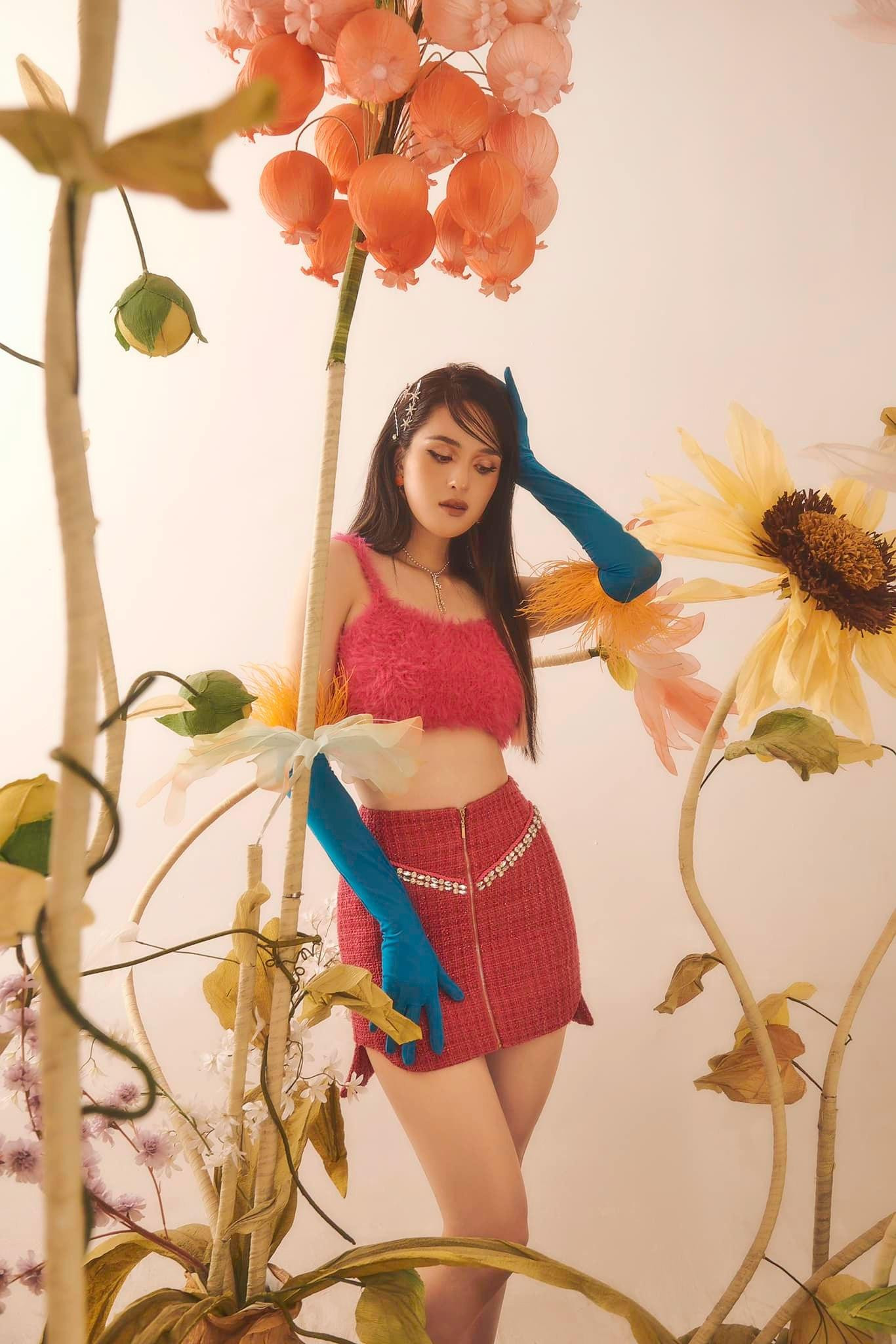 Áo crop-top chất liệu lông vũ màu hồng kết hợp với chân váy cùng tông màu và phong cách trang điểm ấn tượng khiến Hoàng Anh trông như các nữ idol Hàn Quốc sành điệu và ngọt ngào.