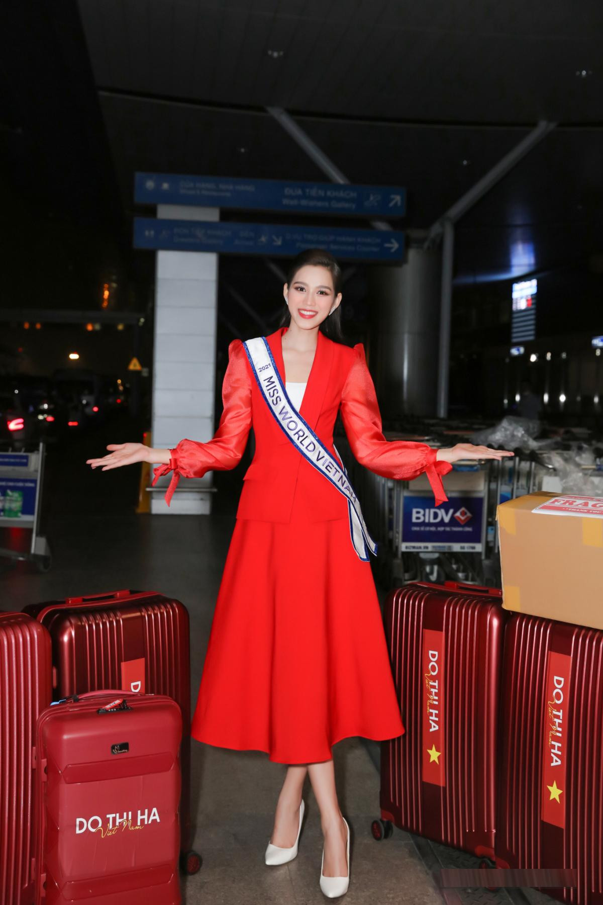 Trong lần đầu tiên ra sân bay để sang Puerto Rico tham dự cuộc thi Miss World 2021, Hoa hậu Đỗ Thị Hà xuất hiện cực kỳ xinh đẹp và yêu kiều với bộ váy xoè phom dáng cổ điển tông màu đỏ nổi bật.