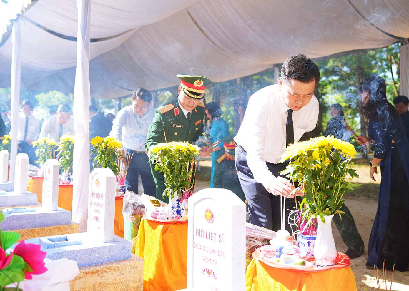 Thắp hương cho các phần mộ liệt sĩ vừa được an táng