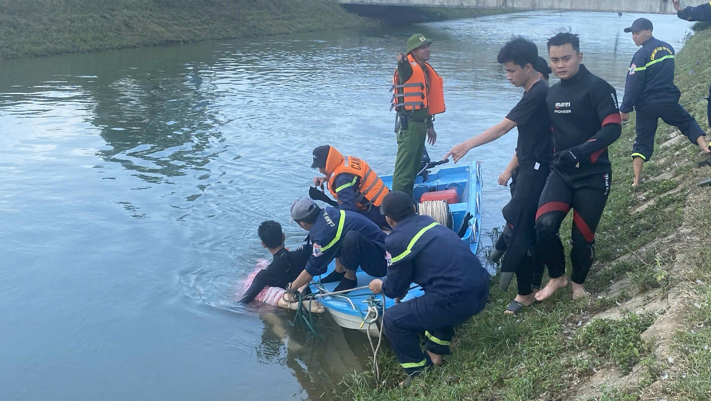 Lực lượng chức năng đưa thi thể nam sinh L.Q.H. lên bờ.