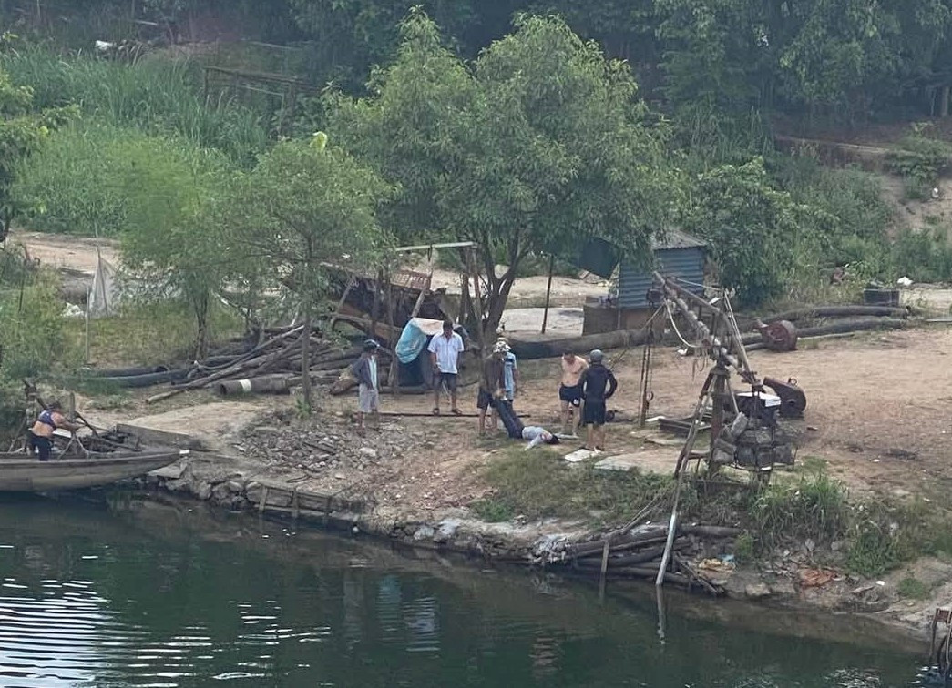 Sau khi đưa lên bờ, người dân sơ cấp cứu cho người phụ nữ bị đuối nước sáng 24/5. Ảnh: MXH