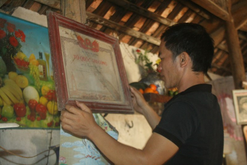 Người cháu ông Chấn treo lại Bằng tổ quốc ghi công lên bàn thờ tổ tiên trước lúc đón ông Chấn về nhà