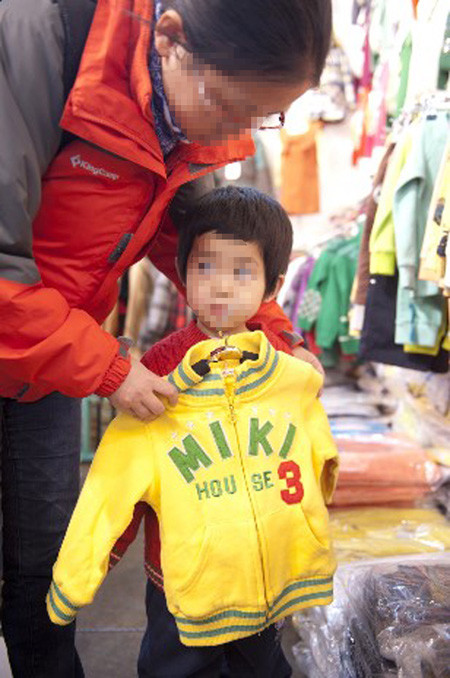 Một bà mẹ thử áo cho con tại Bắc Kinh