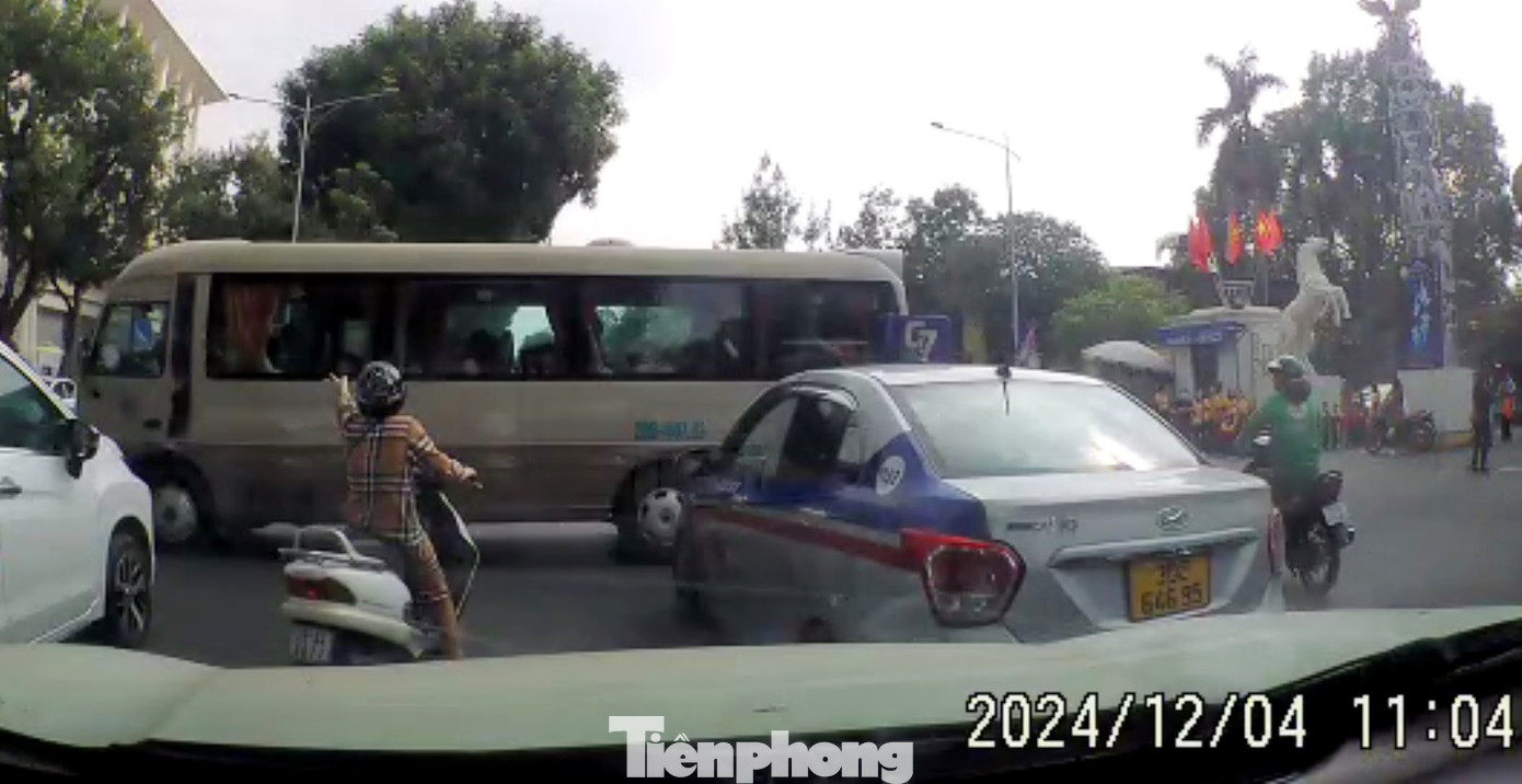 Hình ảnh tài xế xe khách 29B-00732 chạy cắt mặt nhiều phương tiện trên đường Trần Nhân Tông sáng 4/12 và bị người đi đường phản ứng. Ảnh cắt từ clip.