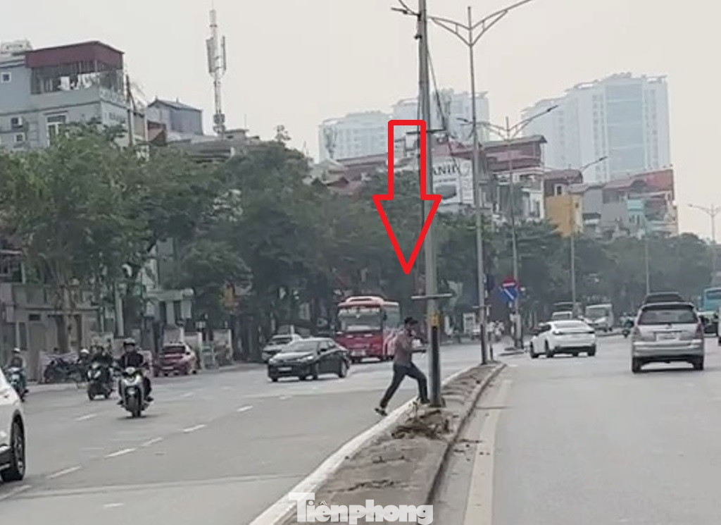 Hàng rào sắt bị nhổ vừa làm dải phân cách trơ trọi, mặt lổn nhổn hố đào, vừa khiến người đi bộ bất chấp các dòng xe đang lưu thông để băng qua đường ở bất kỳ đâu.