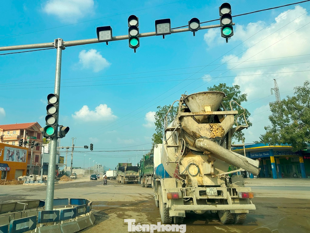 Vừa là quốc lộ vừa là đường đô thị (có đèn xanh, đèn đỏ) nhưng QL45 qua thị trấn Quán Lào đang không khác gì đường làng, xe công trường, xe tải hồ hồ, xe bồn nối đuôi nhau đi thành hàng dài, bịt cả ngã tư.