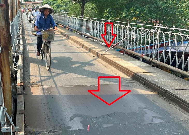 Mặt cầu dành cho xe máy, xe đạp thủng lớn, đơn vị quản lý phải dùng tấm sắt che đậy; bờ lan can cũng nghiêng phải dùng các đoạn sắt ngắn hàn giữ lại (mũi tên đỏ). Mặt cầu dành cho xe máy, xe đạp thủng lớn, đơn vị quản lý phải dùng tấm sắt che đậy; bờ lan can cũng nghiêng phải dùng các đoạn sắt ngắn hàn giữ lại (mũi tên đỏ).