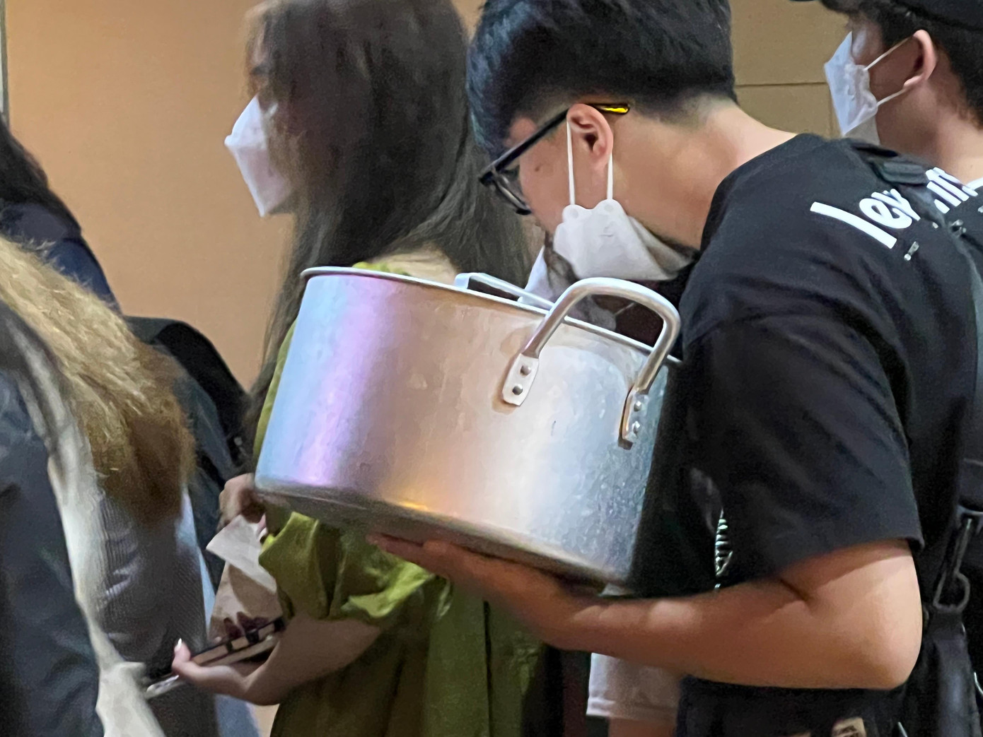Một thanh niên mang cả nồi nấu ăn hàng ngày để đựng.