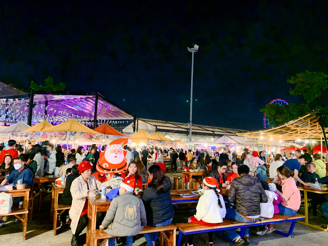 Bàn ghế khu ăn uống tại chợ đêm chật kín, khách ra vào liên tục.