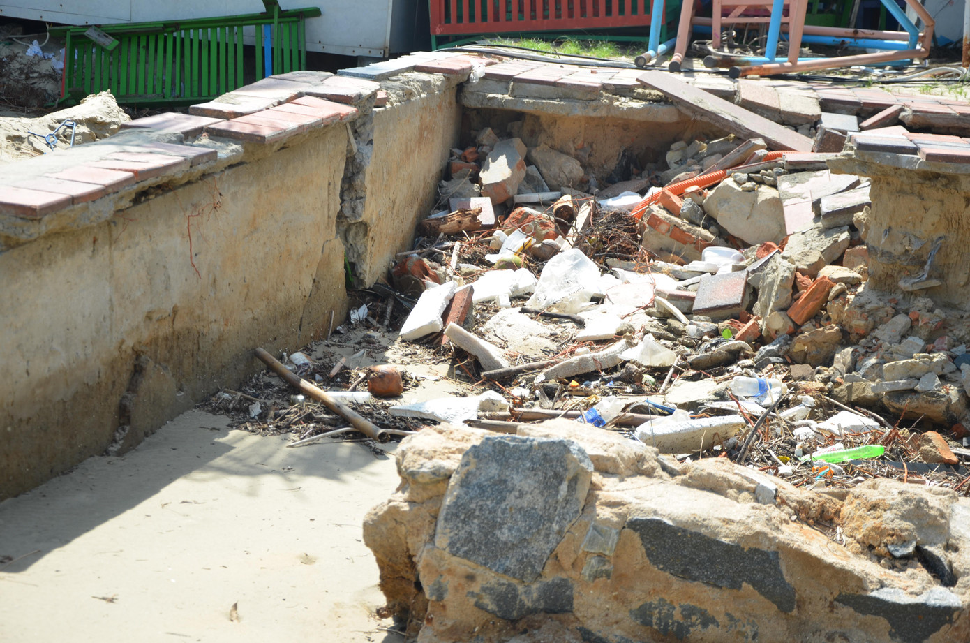 Tại một điểm sạt lở đường Hoàng Sa, cát, đá, rác...vẫn nằm ngổn ngang dưới hố sâu gần một mét. Ảnh: Thái Lâm.
