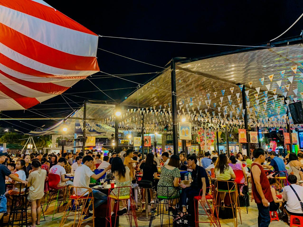 Ngoài ra, chợ đêm lớn nhất Đà Nẵng Helio tối 3/9 cũng đón hàng ngàn lượt du khách tham quan. Quầy đồ ăn bán hàng liên tục, bàn ghế kín chỗ.