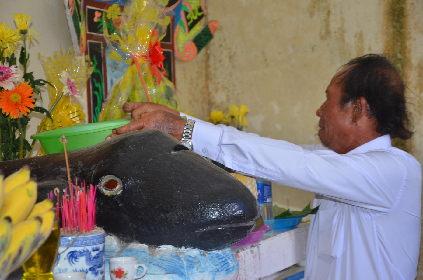 Ông Nguyễn Vũ, thư kí Hiệp hội nghề cá phường Nại Hiên Đông bày tỏ, việc lập đền thờ và hàng năm tổ chức lễ cầu Ngư là văn hóa tâm linh lâu đời của bà con ngư dân. Vì sự mưa may, nắng rủi lênh đênh trên mặt biển, lớp lớp ngư dân bao đời trước cho đến con cháu đời nay đều mang trong lòng niềm tâm linh cầu nguyện những vị thần ở biển khơi, giúp cho ngư dân may mắn trong cuộc trường chinh tìm kế sinh nhai nơi miền sông nước. Trong ảnh: Ngư dân đặt thau nước rước Thủy Thần lên bàn thờ bên cạnh tượng cá Ông.