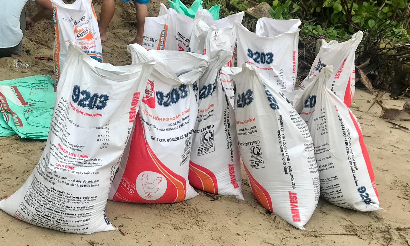 Bao cát được sắp đống, cột dây thép chờ chuyển lên mái nhà.