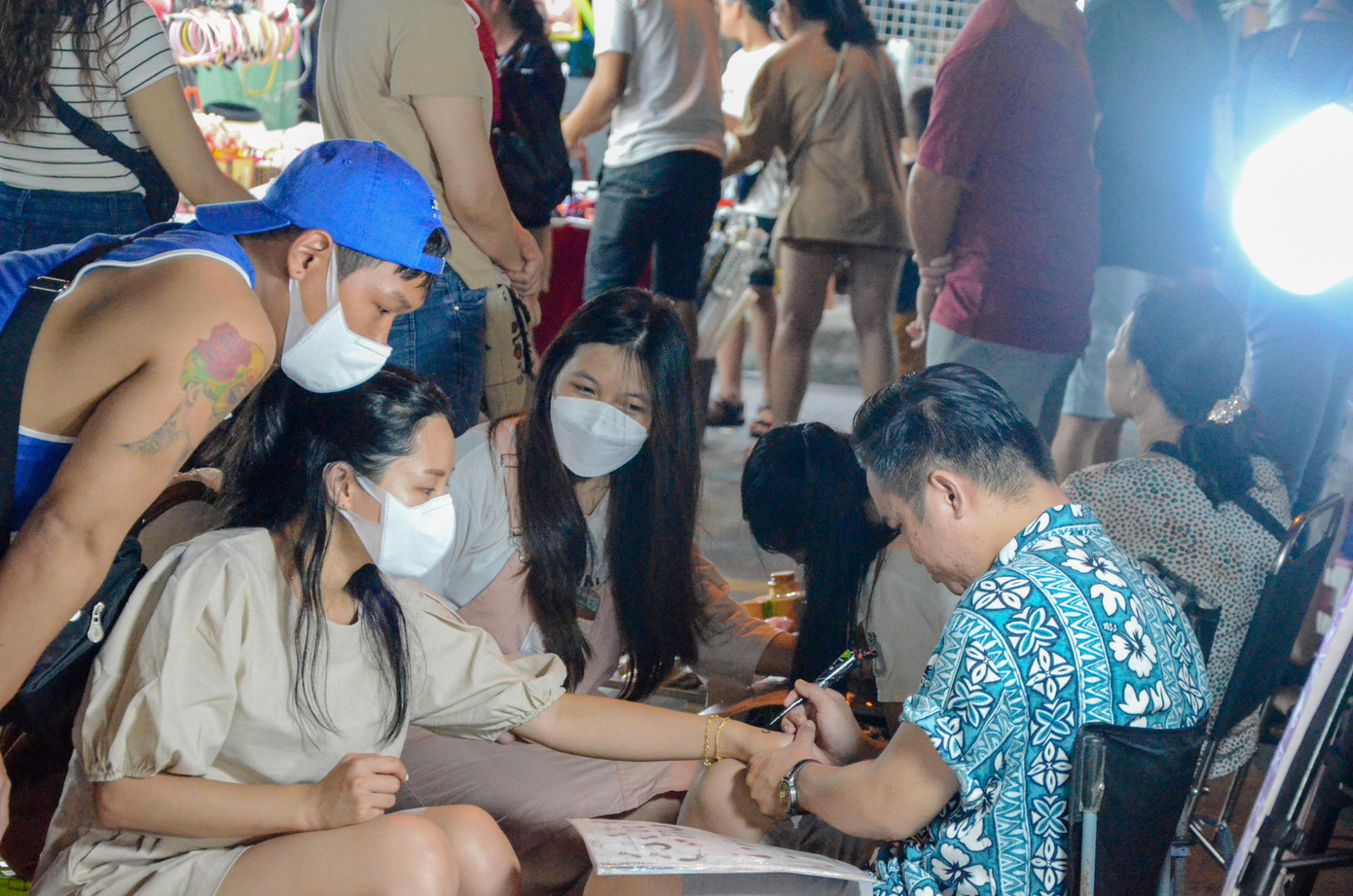 Nhiều du khách trẻ trải nghiệm xăm hình.