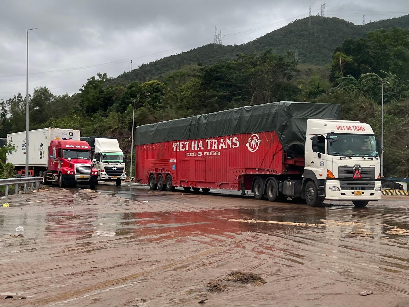 Nhiều xe container đậu giữa đường vì hầm Hải Vân chưa lưu thông. Theo ông Võ Ngọc Trung, Phó Tổng Giám đốc Công ty CP Đầu tư hạ tầng giao thông Đèo Cả, đơn vị đang gấp rút thông hầm, dự kiến đến tầm 16 giờ chiều nay hầm sẽ thông hết làn.