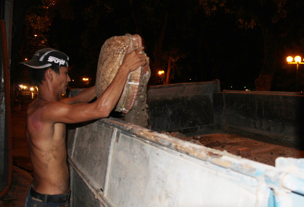 Một chiếc thùng xe 4 khối được đổ đầy, ba nam thanh niên này sẽ nhận được 120 nghìn tiền công. Ảnh: Trường Phong