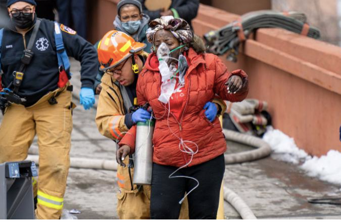 Một người dân được lính cứu hoả đưa ra khỏi toà nhà cháy. (Ảnh: CNN)