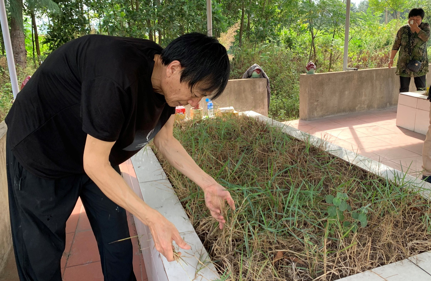 Hình ảnh bố mẹ hai nạn nhân từ Trung Quốc đến Hà Tĩnh thăm mộ các con.