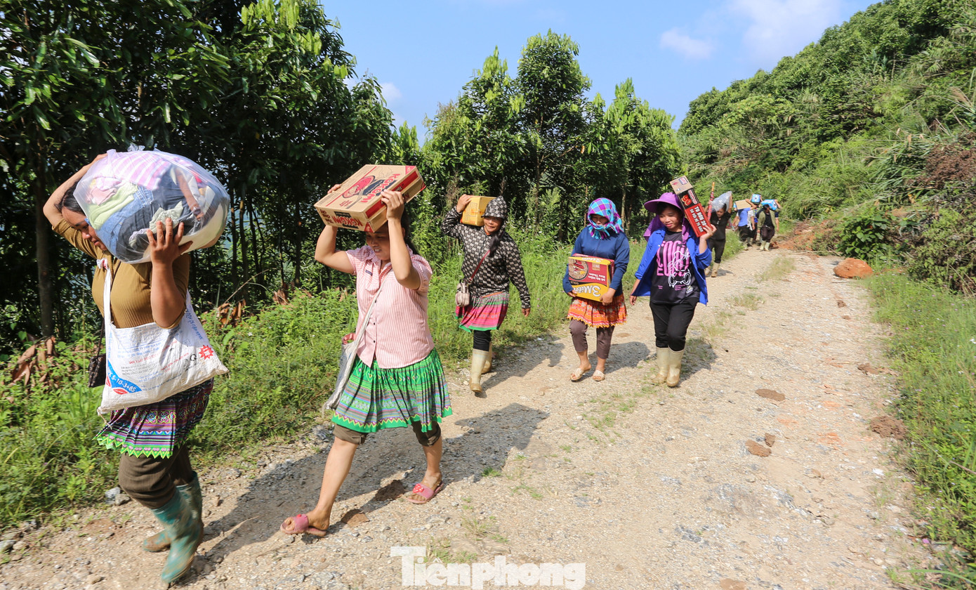 “Mỗi ngày em đi 2 chuyến, gùi được khoảng 20kg hàng hóa vào cho người dân. Kết thúc một ngày đi bộ gần 40, khi về đến nhà em lăn ra ngủ, đôi chân rã rời. Nhưng vì người dân gặp hoạn nạn, sáng sớm em lại cố dậy sớm, tiếp tục ra trung tâm xã gùi hàng vào cho dân”, Mô tâm sự. Trong hình, thanh niên địa phương mang nhu yếu phẩm vượt qua khu vực sạt lở để đưa vào tiếp tế cho người dân vùng sạt lở.