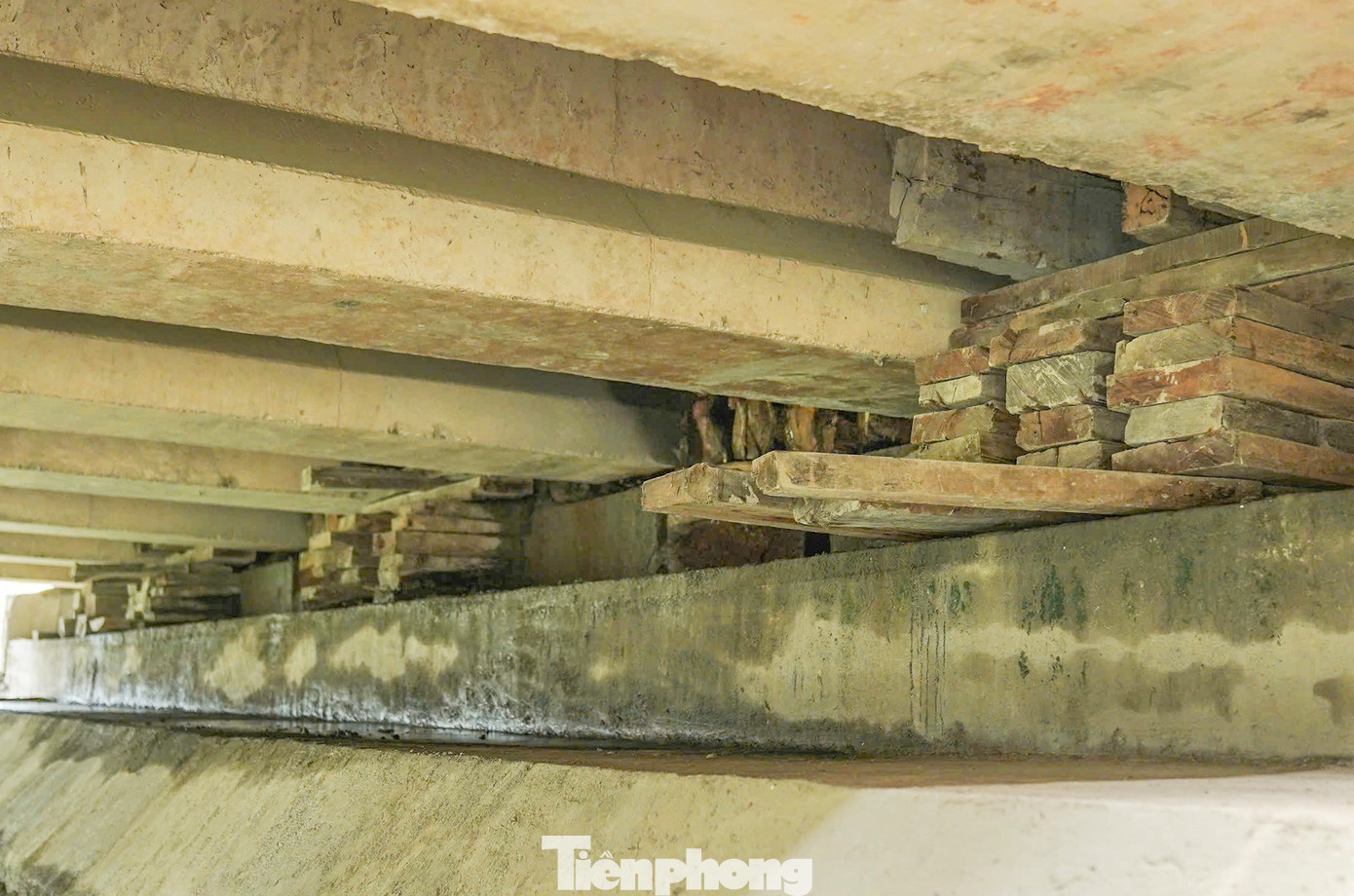 Nhìn xuống dưới cầu, nhiều người dân khá bất ngờ khi đơn nguyên cầu chiều Nam - Bắc đang phải kê nhiều tấm ván gỗ tại mố cầu.