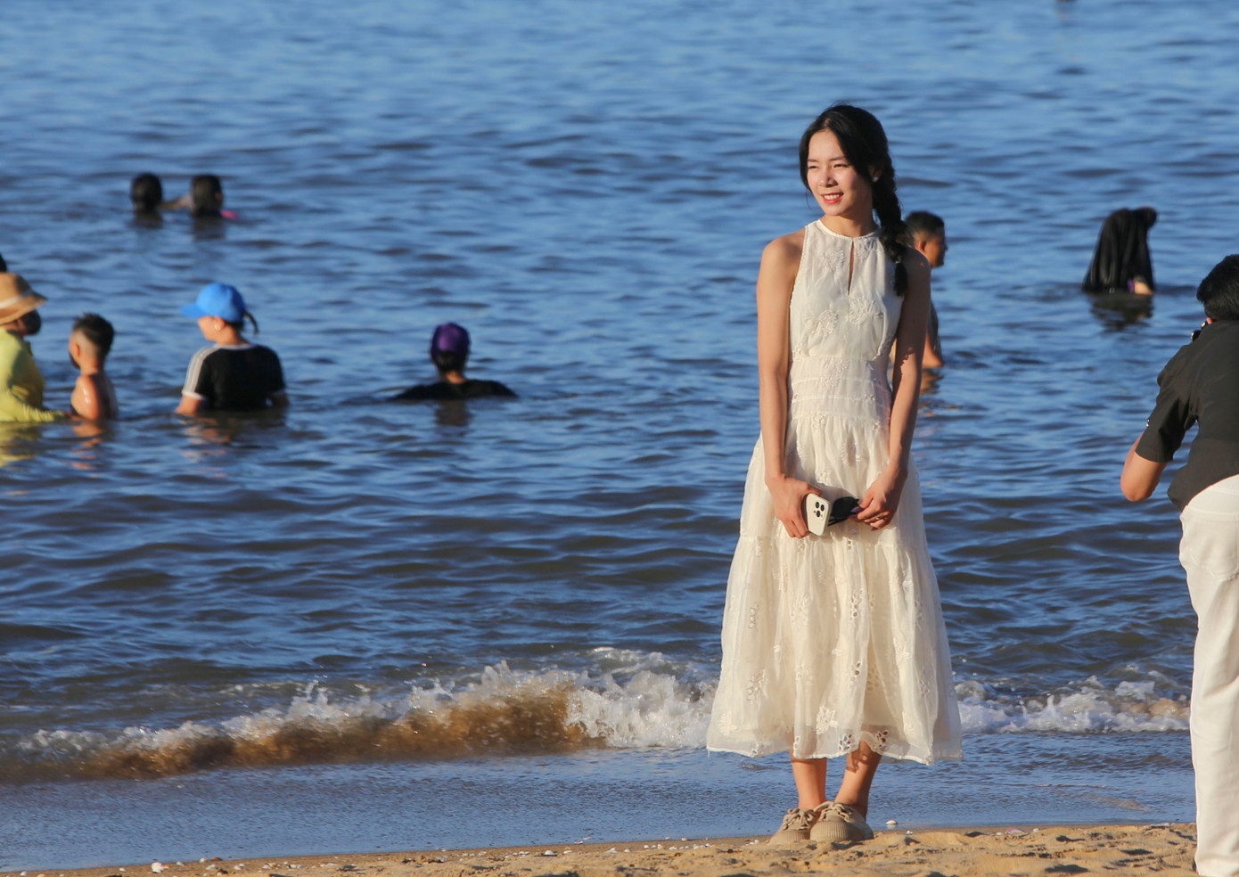 Một số bạn trẻ khác vui vẻ check-in trên bờ hoặc hòa mình vào làn nước trong xanh, mát rượi ven bãi cát mịn.